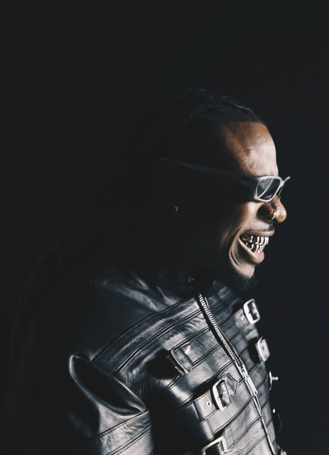 RudeboyFinesse smiling in sunglasses and a black leather jacket